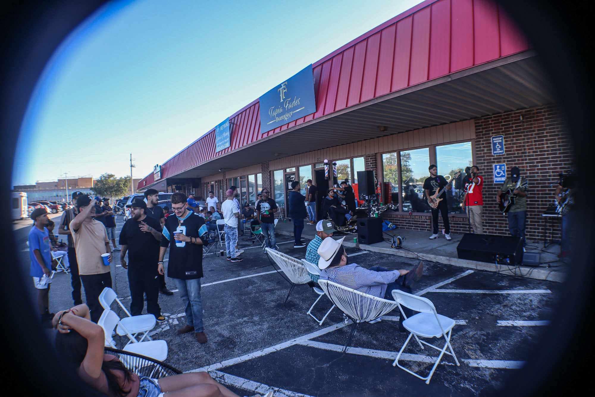 Outdoor community event at Tapia Fades Barbershop featuring KC Fade Wars barber battle with live music, barbers, and attendees gathering outside.