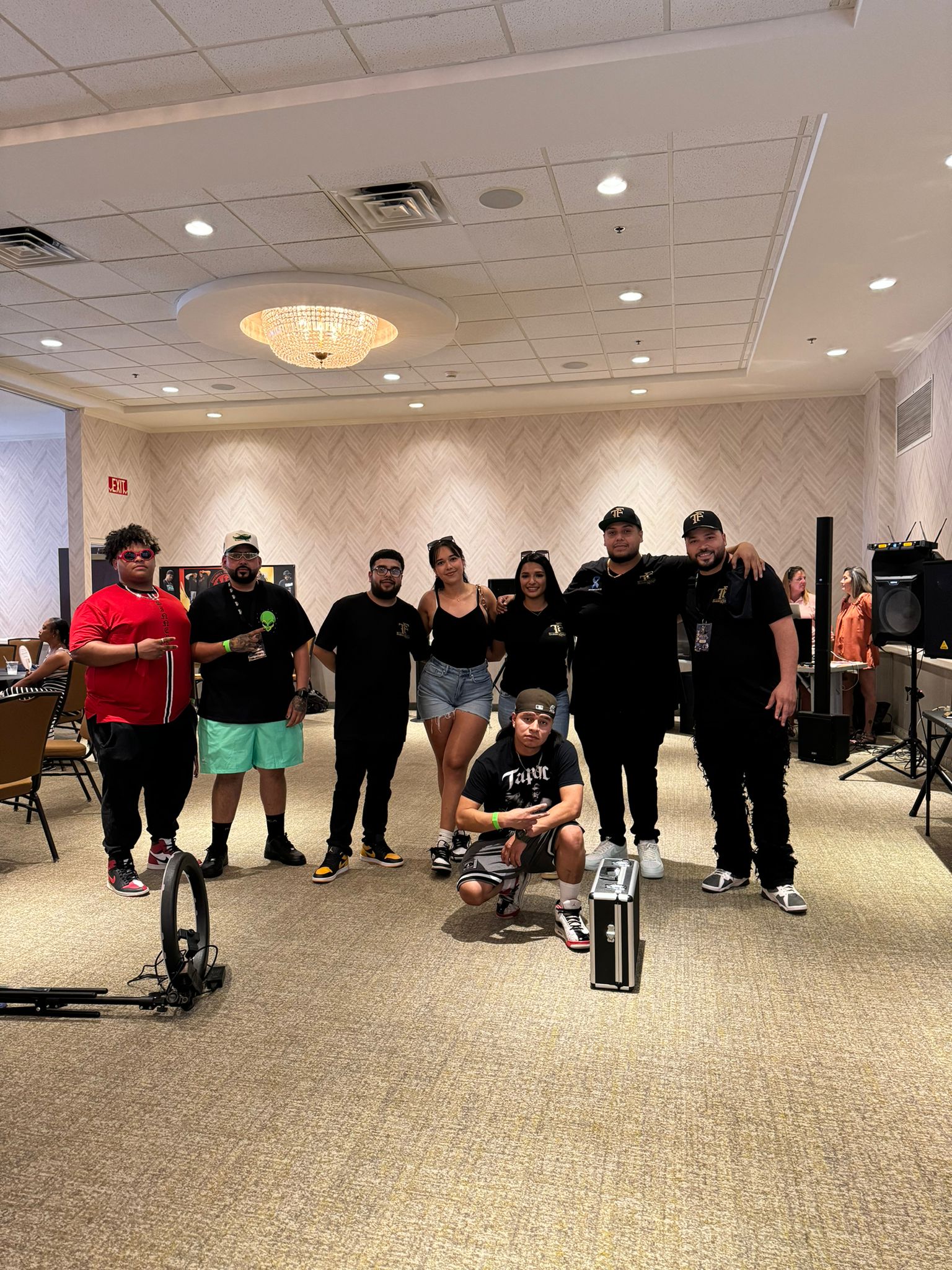 Group photo of KC Fade Wars event team and attendees at a past barber competition, showing barbers and supporters together indoors.
